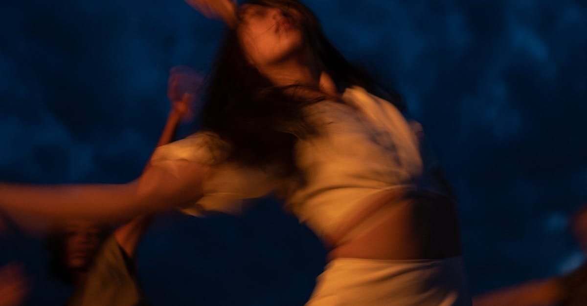 Blurred movement of women dancing joyfully during nighttime, creating an ecstatic and dreamy atmosphere.