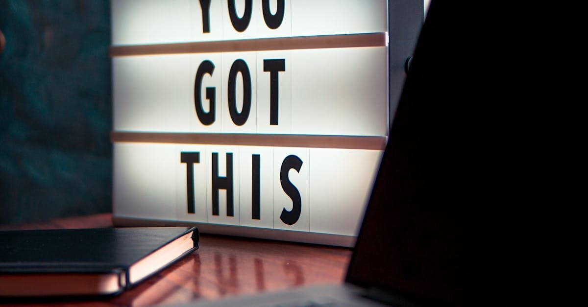 Illuminated lightbox with a motivational quote beside a laptop, promoting productivity.