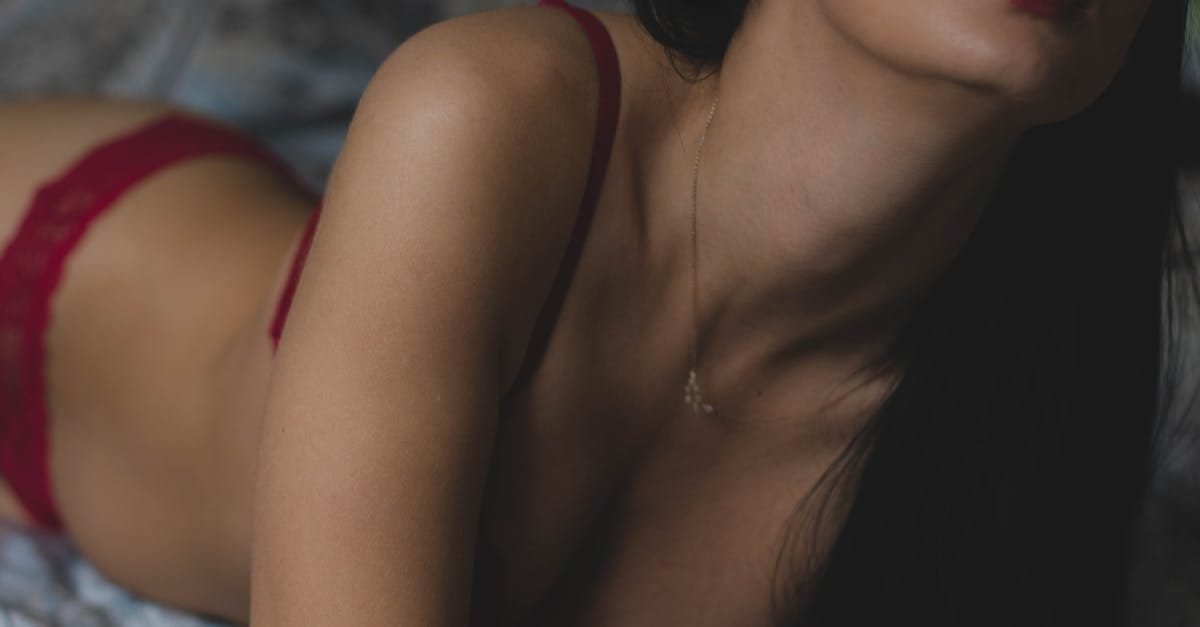 Close-up artistic shot of a woman in red lingerie with a necklace, capturing elegance and allure.
